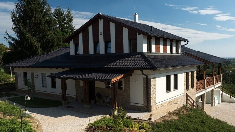 moderny-dom-cierna-strecha-biela-fasada-kombinovana-s-drevenym-a-kamennym-obkladom